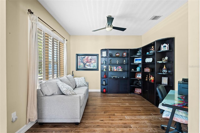 home office with dark hardwood / wood-style flooring and ceiling fan