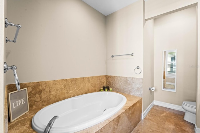 bathroom with tiled tub, toilet, and tile patterned flooring