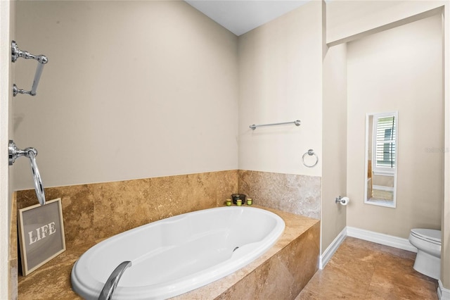 full bathroom featuring tile patterned flooring, baseboards, toilet, and a garden tub