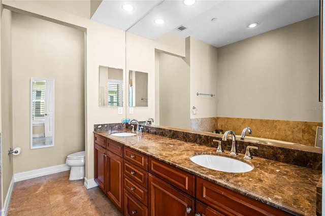 bathroom with double vanity, toilet, recessed lighting, and a sink
