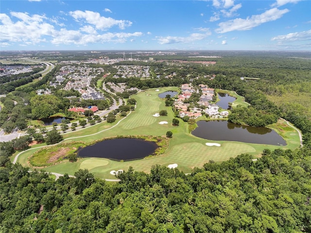 aerial view with golf course view, a view of trees, and a water view