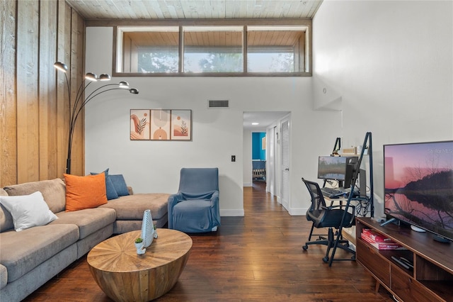 living room with dark wood-type flooring, wood ceiling, and a towering ceiling