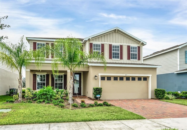 view of front of house featuring a front yard, central AC, and a garage