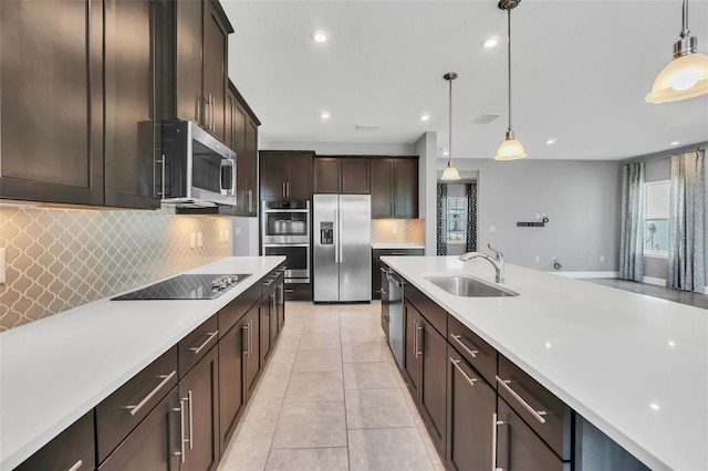 kitchen with sink, pendant lighting, dark brown cabinets, and stainless steel appliances