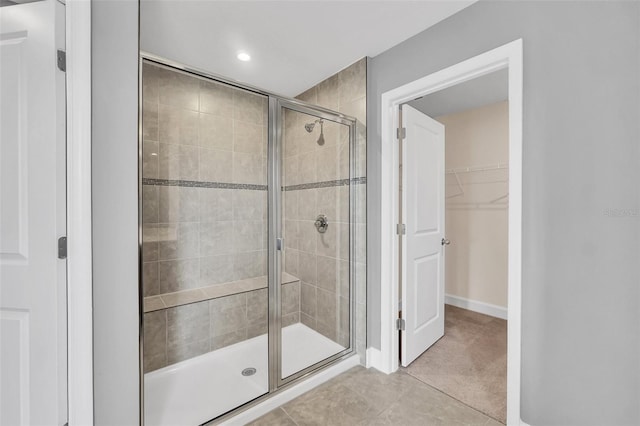 bathroom featuring a shower with door and tile patterned flooring