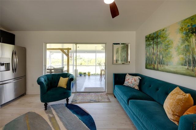 living room featuring vaulted ceiling, light hardwood / wood-style flooring, and ceiling fan