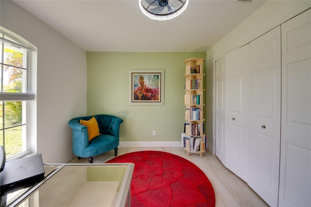 living area with light hardwood / wood-style flooring and ceiling fan