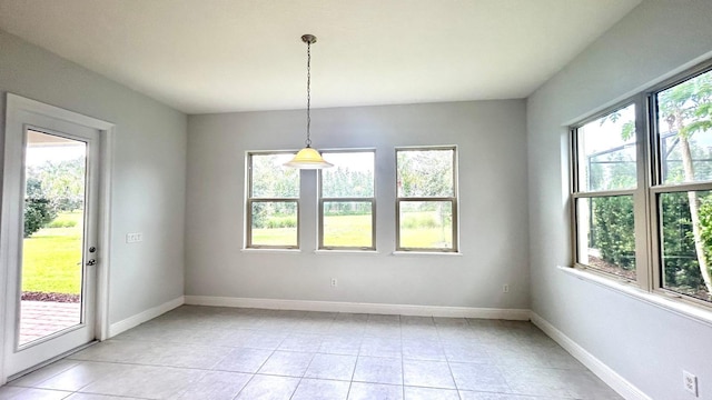 unfurnished dining area featuring light tile patterned floors and plenty of natural light