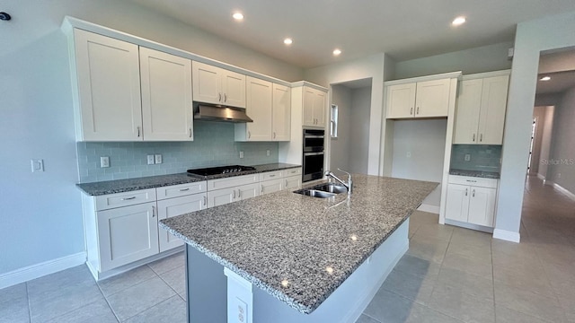 kitchen with a center island with sink, backsplash, black gas stovetop, white cabinetry, and sink