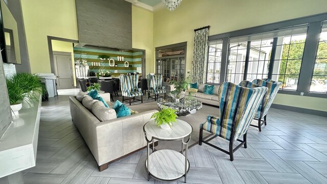 living room featuring a towering ceiling and crown molding