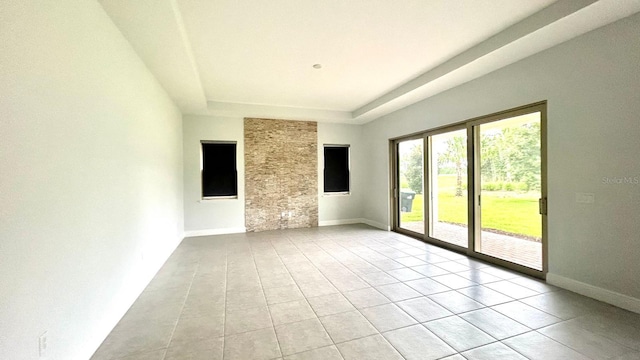 tiled empty room with a raised ceiling