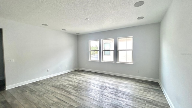 spare room with wood-type flooring and a textured ceiling