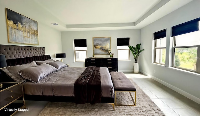 tiled bedroom with a tray ceiling