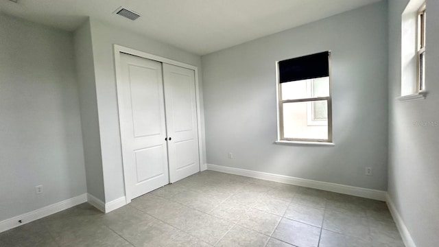 unfurnished bedroom with a closet and light tile patterned floors