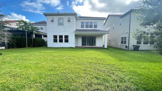 rear view of house featuring a lawn