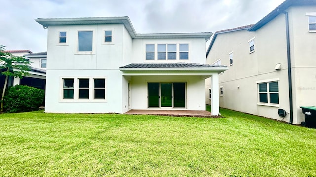 back of property with a yard and a patio