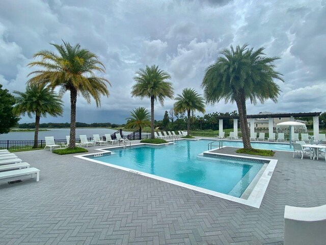 view of pool with a patio area and a water view