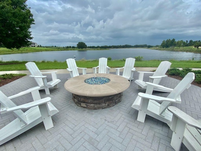 view of patio with an outdoor fire pit and a water view