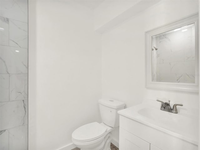 bathroom featuring vanity, toilet, and a tile shower