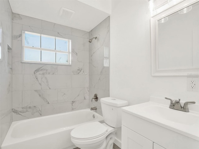 full bathroom featuring tiled shower / bath combo, vanity, and toilet