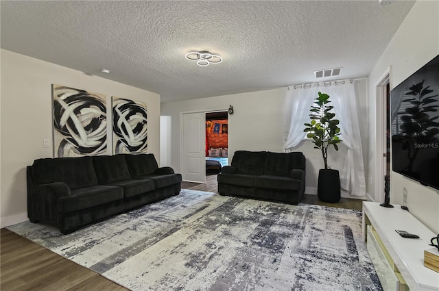 living room with a textured ceiling and hardwood / wood-style floors