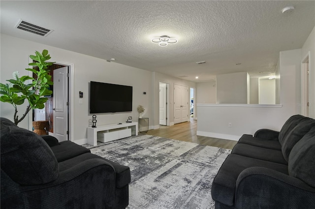 living room featuring light hardwood / wood-style floors and a textured ceiling