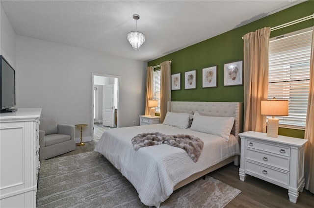 bedroom featuring dark wood-type flooring and a notable chandelier