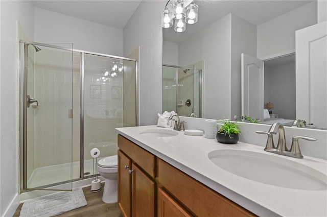 bathroom featuring vanity, walk in shower, wood-type flooring, toilet, and a notable chandelier