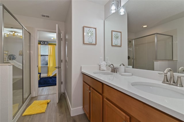 bathroom with an enclosed shower, vanity, and hardwood / wood-style flooring