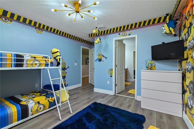 bedroom featuring a textured ceiling, hardwood / wood-style floors, ensuite bathroom, and a chandelier