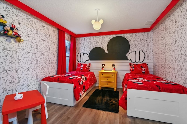 bedroom with wood-type flooring and a textured ceiling