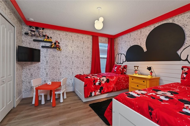 bedroom featuring a textured ceiling, hardwood / wood-style floors, and a closet