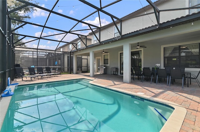 view of swimming pool featuring ceiling fan, glass enclosure, and a patio