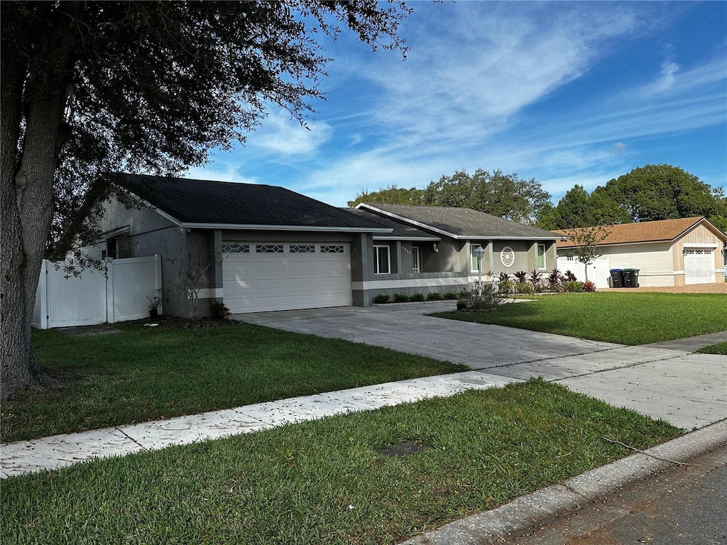 single story home featuring a front yard and a garage