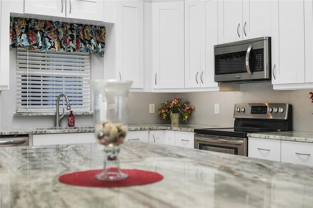 kitchen with white cabinetry, stainless steel appliances, and sink