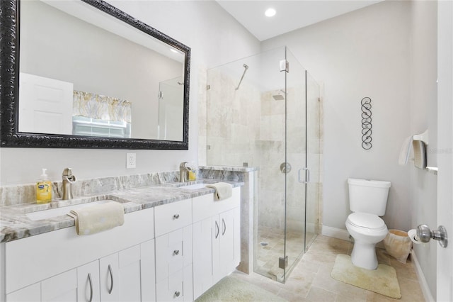 bathroom featuring vanity, a shower with shower door, and toilet