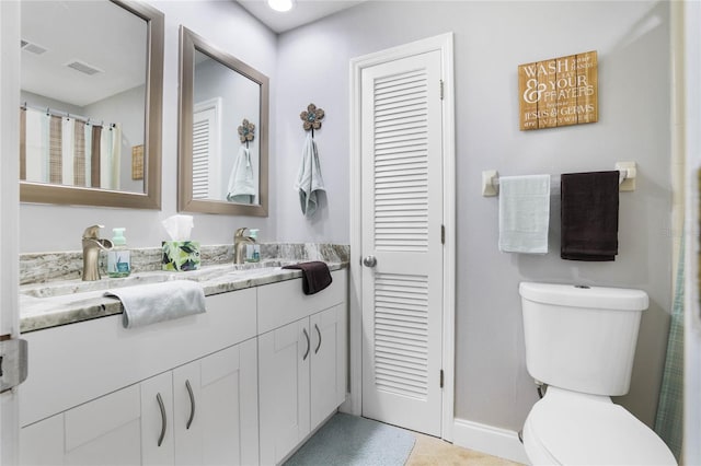 bathroom with vanity, tile patterned flooring, and toilet