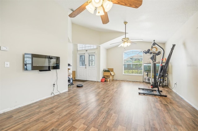 workout area with vaulted ceiling, ceiling fan, and hardwood / wood-style floors