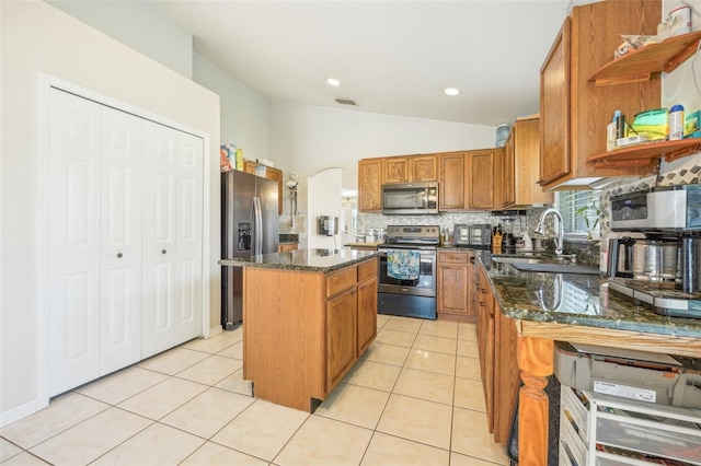 kitchen with light tile patterned floors, stainless steel appliances, lofted ceiling, a center island, and sink