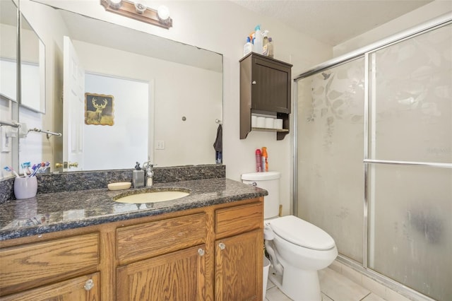 bathroom with vanity, toilet, tile patterned floors, and a shower with door