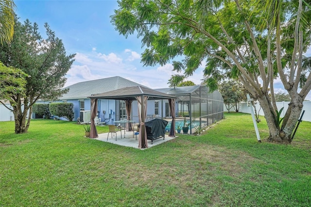 back of house with glass enclosure, a patio area, and a yard