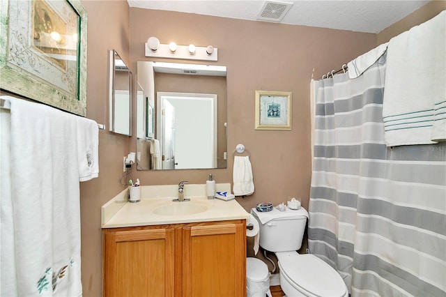 bathroom with vanity, toilet, and a textured ceiling