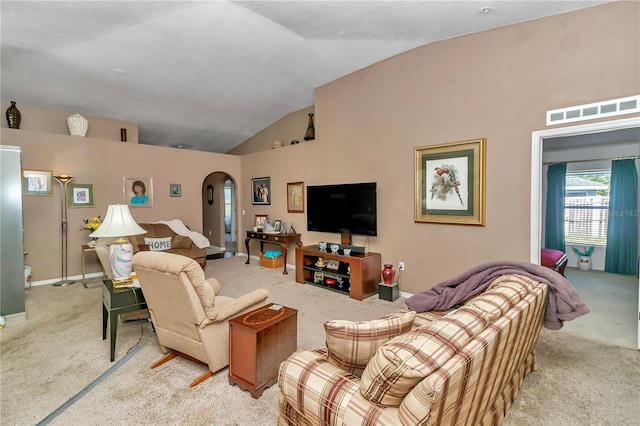 carpeted living room with high vaulted ceiling