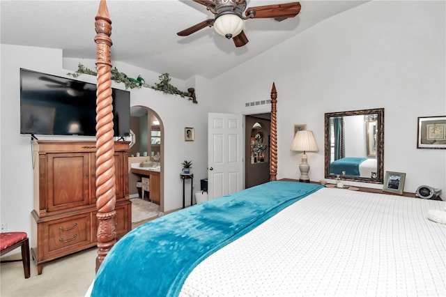 bedroom featuring ensuite bathroom, ceiling fan, light colored carpet, and lofted ceiling