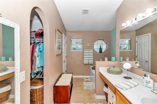 bathroom with vanity and a tub