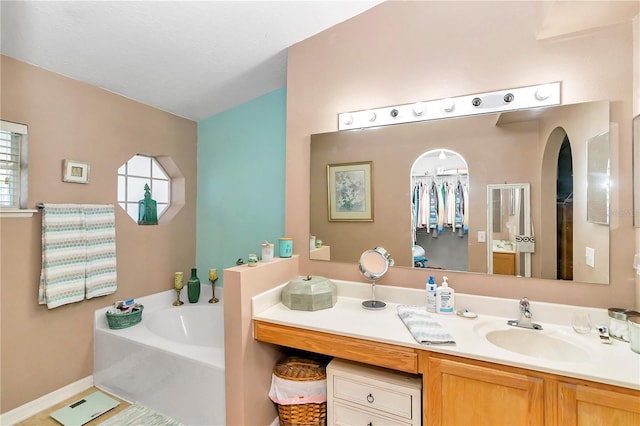 bathroom with a washtub and vanity