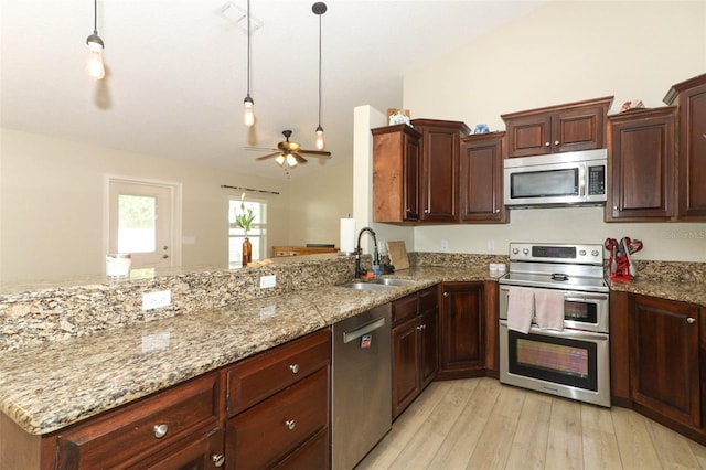 kitchen with hanging light fixtures, stainless steel appliances, light hardwood / wood-style floors, sink, and ceiling fan