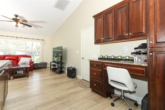 office space with built in desk, ceiling fan, light hardwood / wood-style floors, and vaulted ceiling