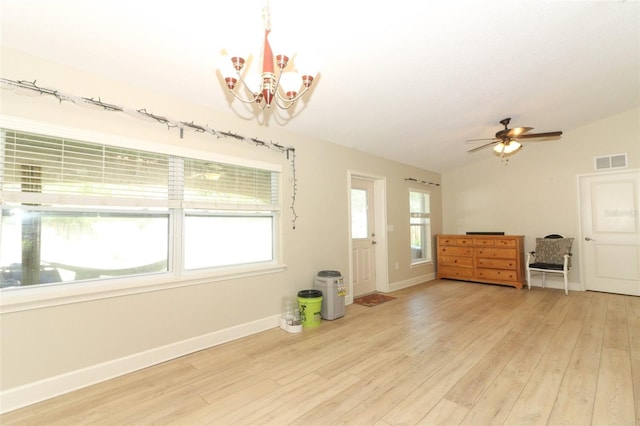 entryway with ceiling fan with notable chandelier, lofted ceiling, and light hardwood / wood-style flooring