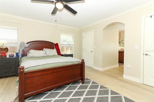 bedroom featuring ceiling fan, ornamental molding, hardwood / wood-style floors, and ensuite bath